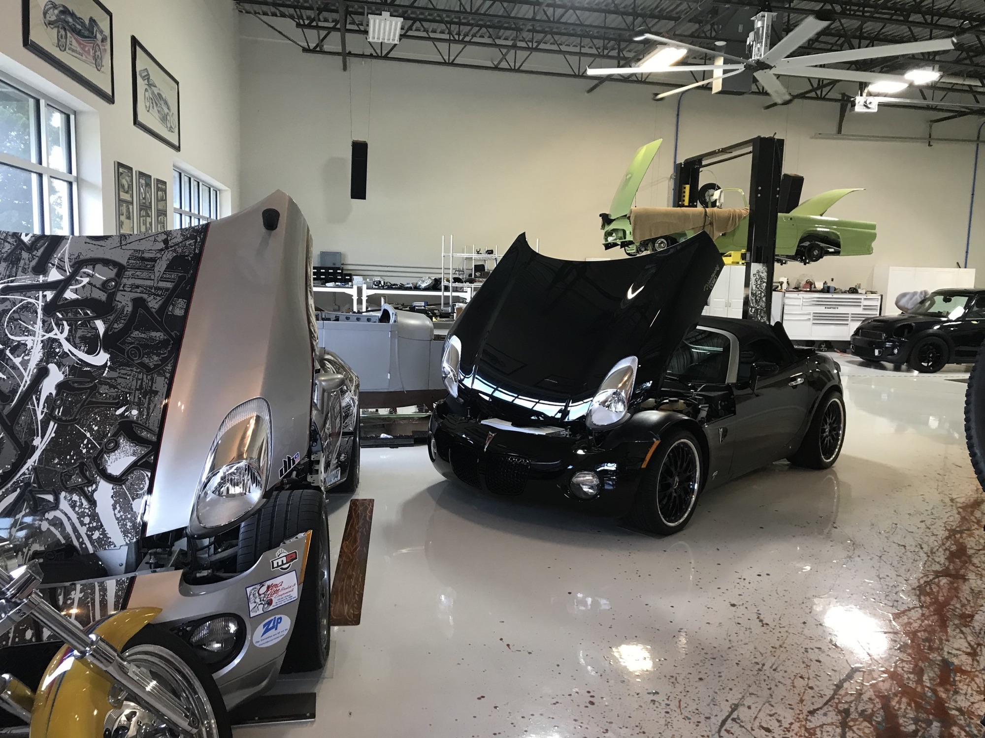 Black Mallett V8 Pontiac Solstice with the hood up in the Mallett Performance Cars shop
